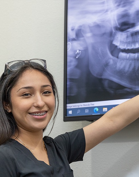Dental team member smiling while providing dental services