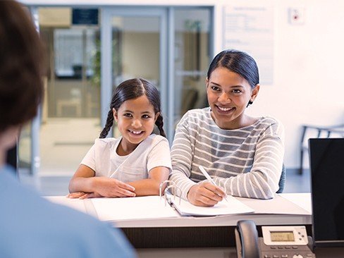 Mother and daughter checking in at reception desk