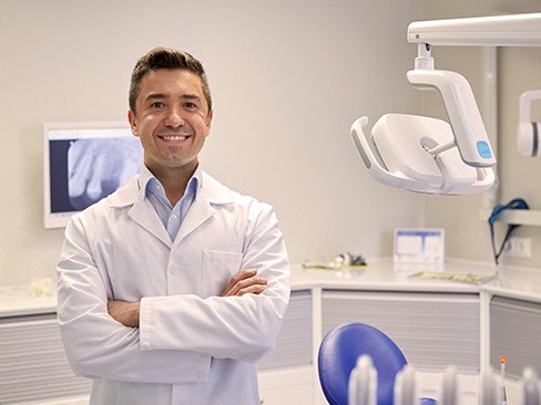 Smiling bilingual dentist in dental exam room