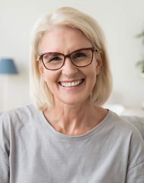 a woman at home and smiling with healthy teeth