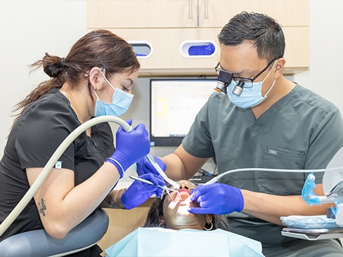 Smiling man in dental chair for dental checkup and teeth cleaning