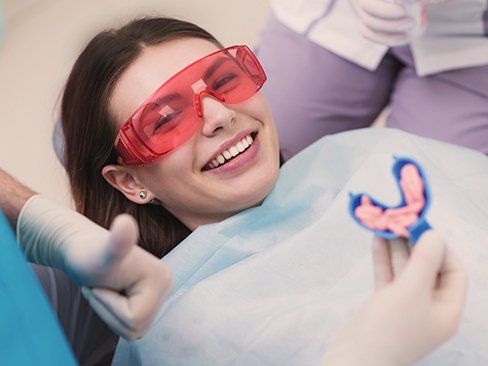 Smiling patient in dental exam chair for fluoride treatment