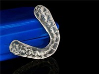 clear aligner next to its blue carrying case
    Does Dental Insurance Cover Invisalign?    
    