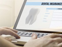 person looking at dental insurance form on laptop 
    Options for Making Invisalign Affordable        
    