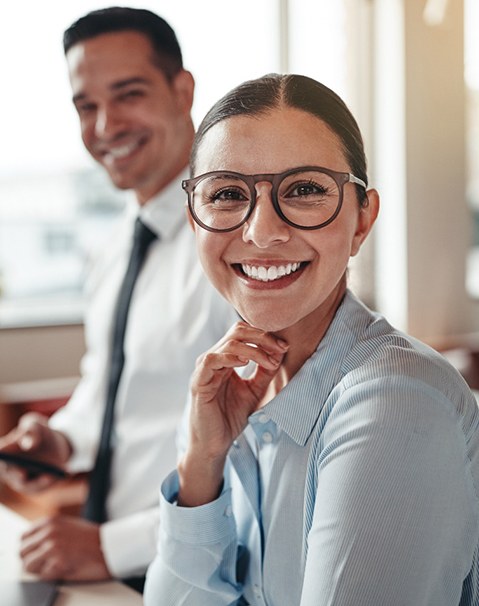 Woman with dental crown in Dallas smiling at work