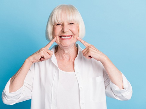 Woman smiling and pointing to her smile