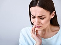 Woman experiencing tooth pain in Dallas