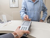 Man paying for dentistry in Dallas