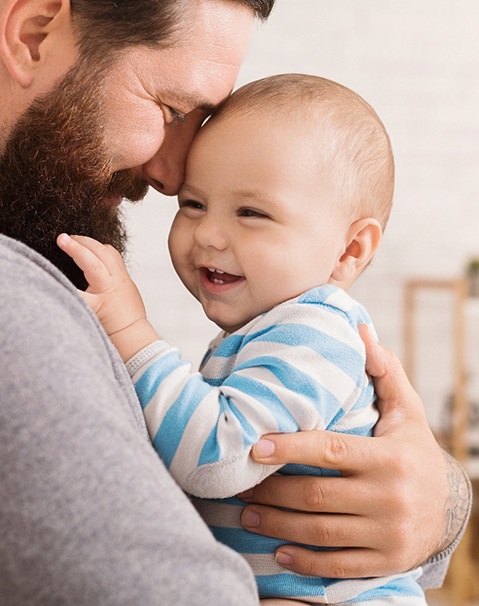 Dad and baby smiling after a frenectomy in Dallas