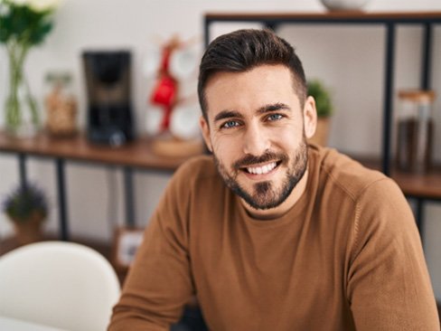 Man sitting down at home and smiling