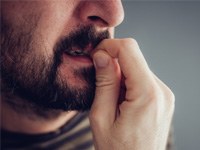 Close-up of a man biting his fingernails