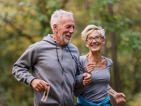 Older couple with implant dentures in Dallas jogging outside