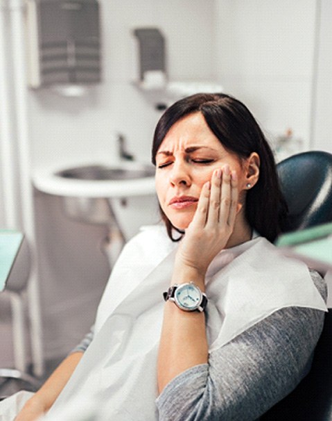 woman with failed dental implant visiting dentist