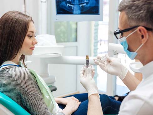 dentist showing a dental implant to a patient