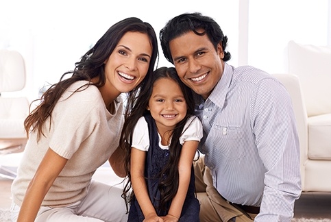 Mother father and child smiling after visiting their dentist in Dallas