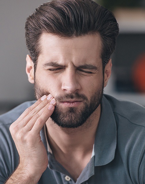 Man in pain holding jaw before root canal therapy