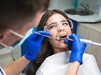 A dentist performing root canal treatment on a woman