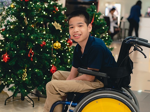 Little boy in a wheelchair smiling