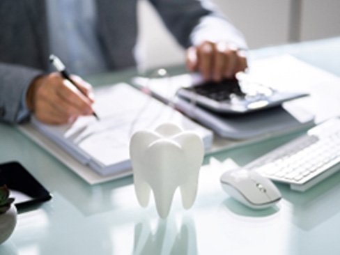 Man in suit calculating cost of traditional braces on desk