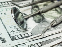 Dental tools lying on pile of money