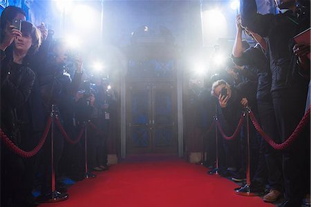 red carpet surrounded by flashing lights and cameras
