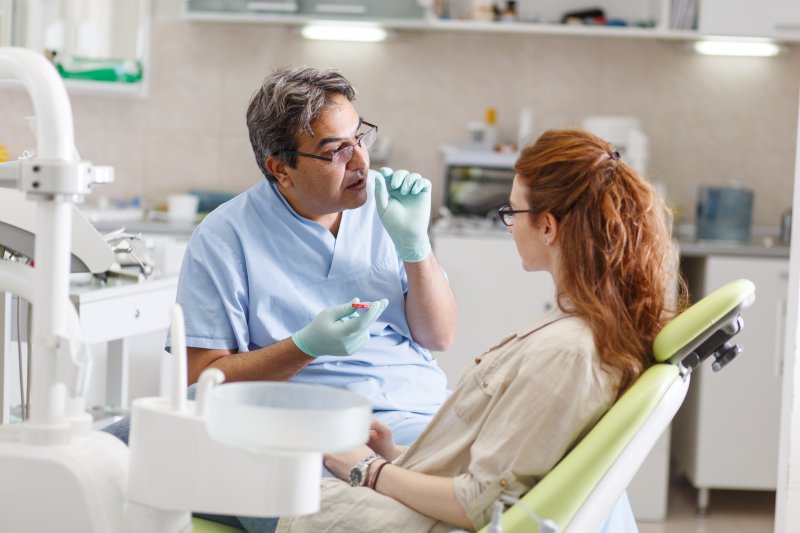 Patient talking with dentist about dental implant surgery