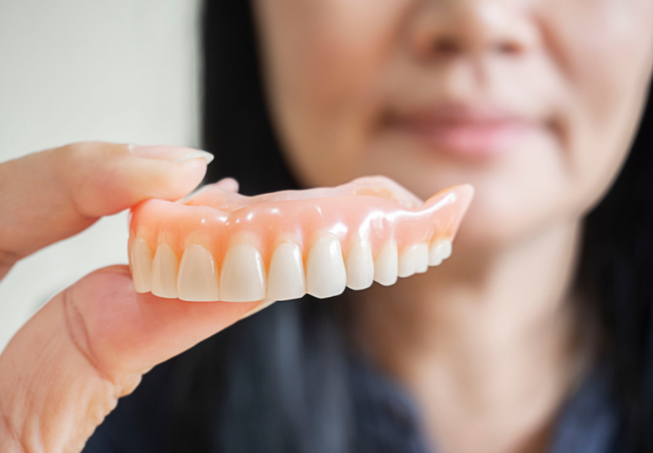 Woman holding denture