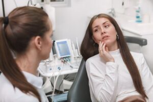 Woman in pain looking at her dentist